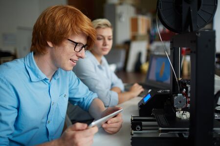 Young designer looking at new product in 3d printer