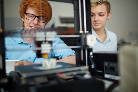 Two young designers printing new model on 3d printerの写真素材