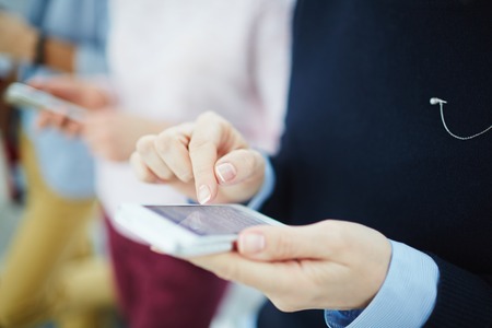 Close-up of female hands texting a message on the phoneの写真素材
