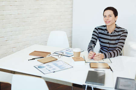 Businesswoman sitting at her workplace and smilingの写真素材
