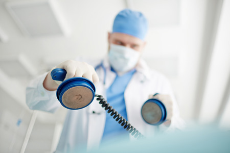 Doctor performing a reanimation with defibrillator at hospitalの写真素材