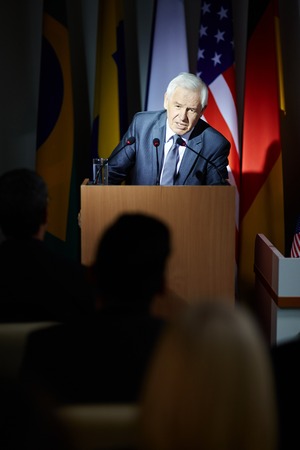 Mature politician speaking from tribuneの写真素材