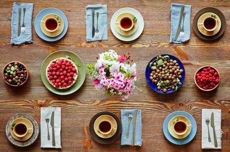 Fresh berries, tea and cake on served table