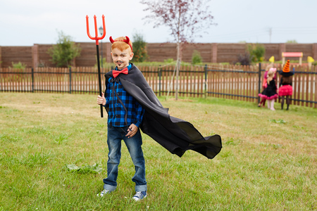 Little boy in costume of devil looking at cameraの写真素材