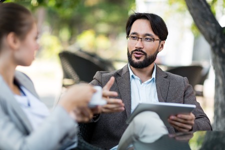 Handsome young businessman talking to co-workerの写真素材