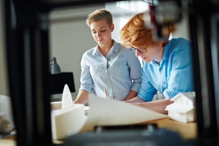 Serious designers drawing sketch of new construction in officeの写真素材