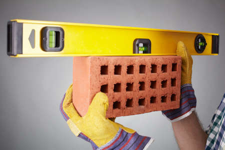 Close-up of brick being measured with a level