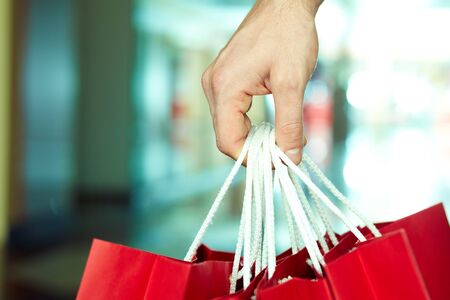 Closeup of male hand holding shopping bagsの写真素材