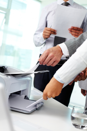 Close up of hands taking documents from printer