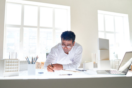 Serious mature architect drawing new sketch in officeの写真素材