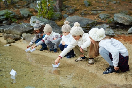 Adorable kids playing with paper shipsの写真素材
