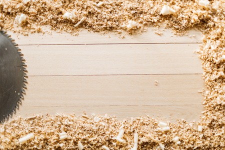 Saw-blade and sawdust on wooden backgroundの写真素材