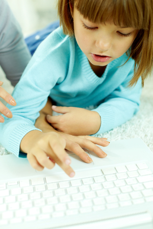 Little girl typing on laptopの写真素材