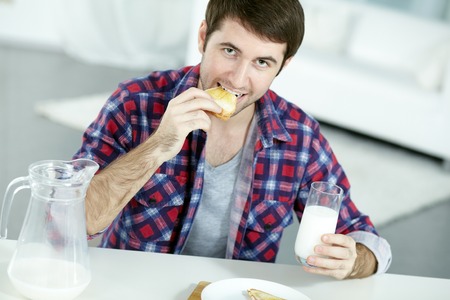 Portrait of man looking at camera while having breakfastの写真素材