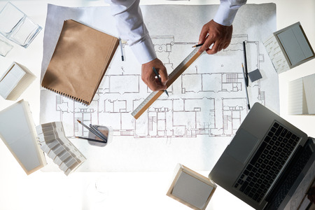 Hands of architect during work at sketch and engineering objects near by