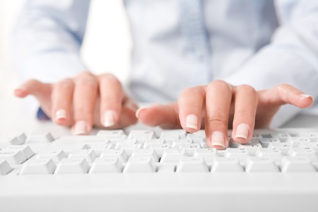Photo of human fingers pushing the buttons of keyboardの写真素材