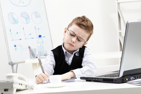 Little boy absorbed in office workの写真素材