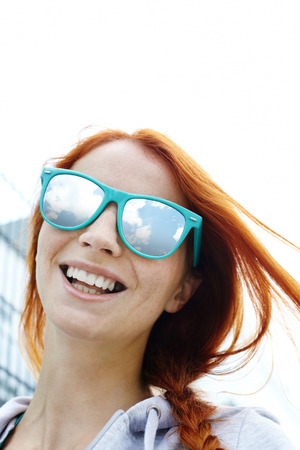 Portrait of a young cheerful girl in sunglasses