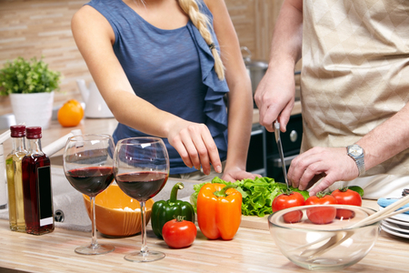 Image of a table with products and a cooking couple by itの写真素材