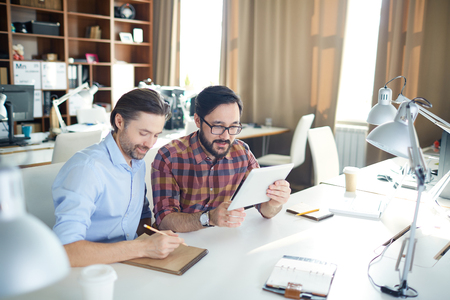 Two businessmen planning work in officeの写真素材