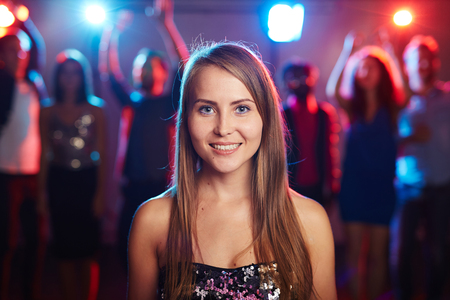 Posh girl with long hair looking at camera at partyの写真素材