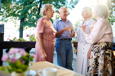 Mature friends having conversation in outdoor cafe at leisureの写真素材