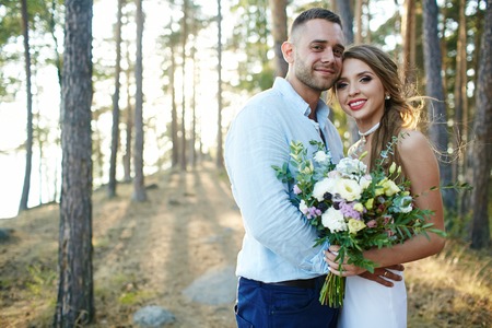 Romantic couple looking at camera in forest after weddingの写真素材