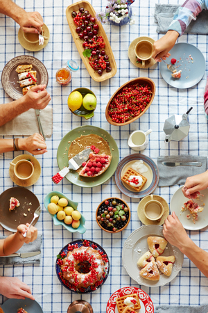 Humans eating tasty Thanksgiving desserts by tableの写真素材