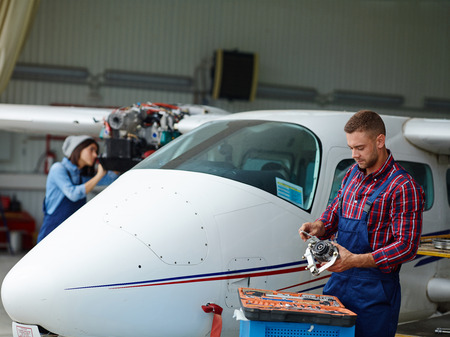 Repairman in uniform choosing spare engine for air jetの写真素材