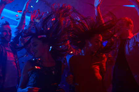 Candid friends taking pleasure in dancing at night clubの写真素材