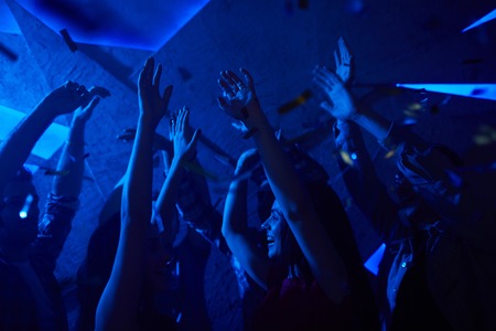Cool friends dancing with raised handsの写真素材
