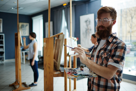 Talented guy painting on canvas with acrylic paintsの写真素材