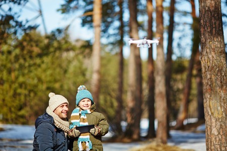 Family of father and son spending day in park and launching droneの写真素材