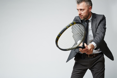 Man in formalwear playing tennisの写真素材