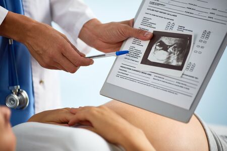 Sonogram of unborn baby in womb being shown and commented by doctor
