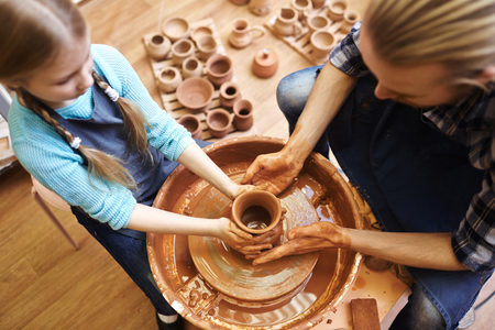 Potter and his daughter making new clay jugの写真素材
