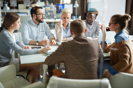 Large group of managers discussing financial data