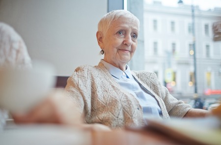 Pretty senior female in casualwear relaxing in cafe