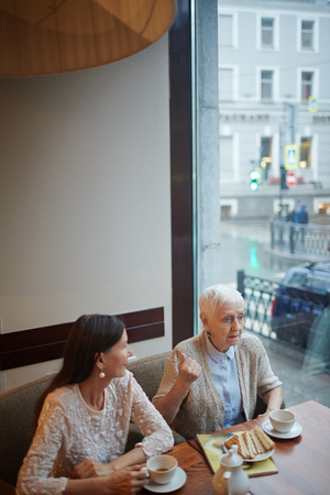 Small group of mature women talking during lunch in cafeの写真素材