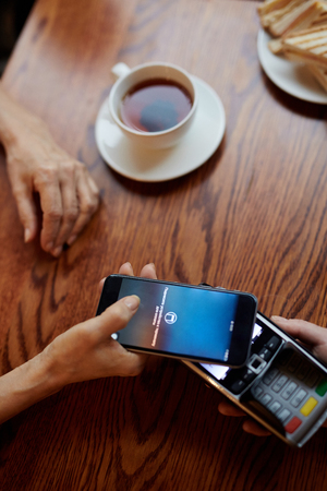 Client paying for snack in cafeteria through nfc technologyの写真素材