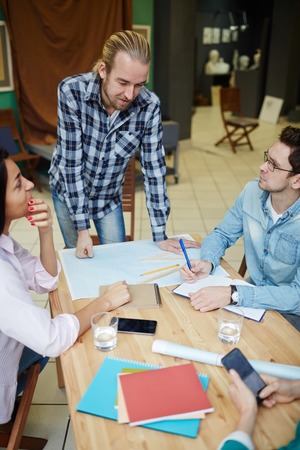 Young coach talking to students of art or design facultyの写真素材