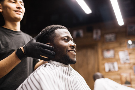 Smiling man sitting in barbershopの写真素材