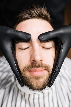 Young man having his face massaged in parlorの写真素材