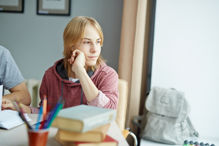 Adolescent guy looking through window at lessonの写真素材