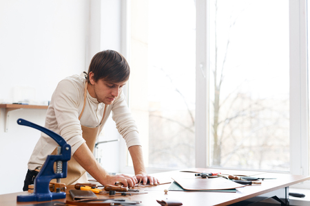 Tanner standing by workplace and workingの写真素材