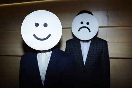 Businessmen in Smiling and Sad Masksの写真素材