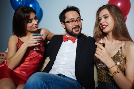 Man enjoying company of attractive womenの写真素材