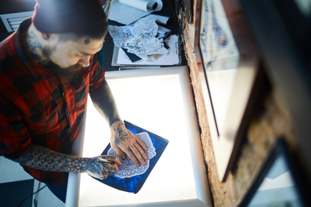 Top view of tattoo maker drawing sketch of creative ornamentの写真素材