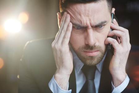 Comfused Businessman Calling by Smartphoneの写真素材