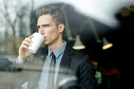Young businessman with paper cupの写真素材